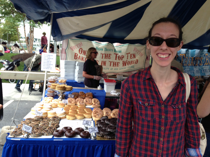 Me in front of the Vegan Treats tent with lots of vegan doughnuts in the background!