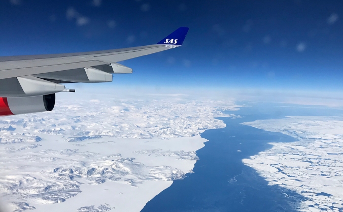 SAS airline plane wing over a snowy and icy landscape